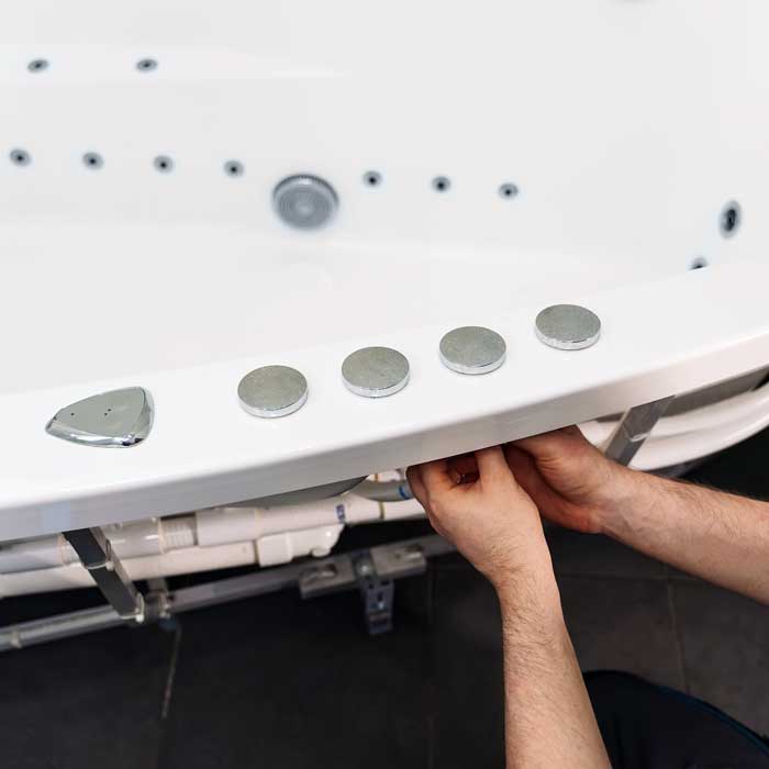 Professional Hot Tub Leak Detection & Repair Services Greater Milwaukee WI A professional fixes a hot tub leak